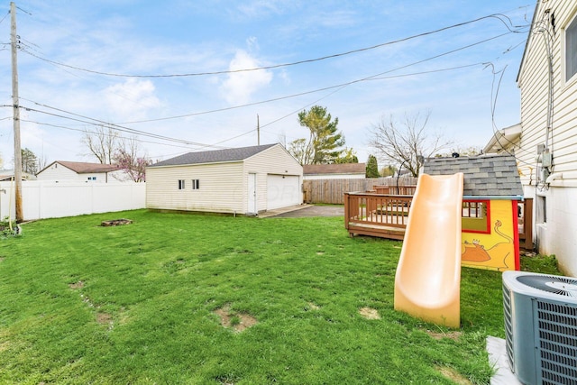 view of yard with an outdoor structure, a deck, a garage, central AC unit, and a fenced backyard