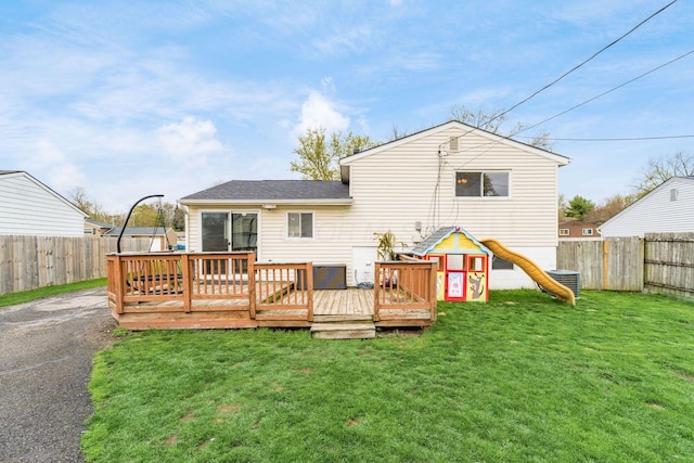 back of property with cooling unit, a yard, a wooden deck, and a fenced backyard