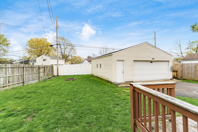 view of yard with a fenced backyard, an outbuilding, and a garage
