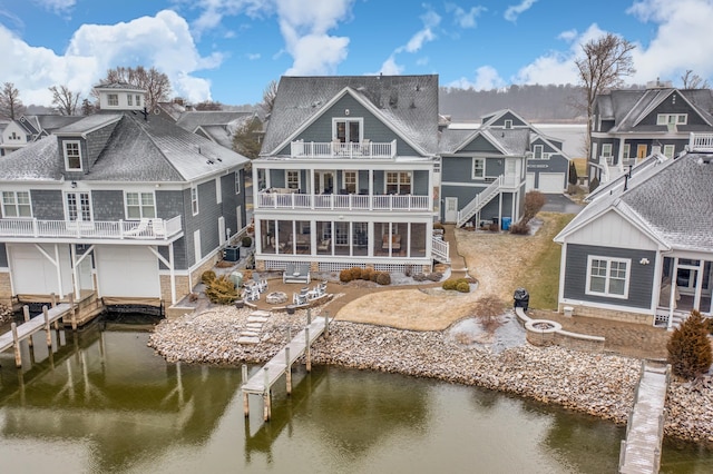 back of property featuring a water view and a fire pit