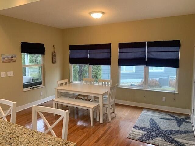 unfurnished dining area with light wood-type flooring and baseboards