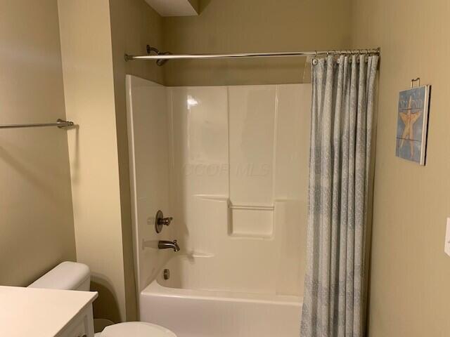 full bathroom with toilet, shower / bath combination with curtain, and vanity