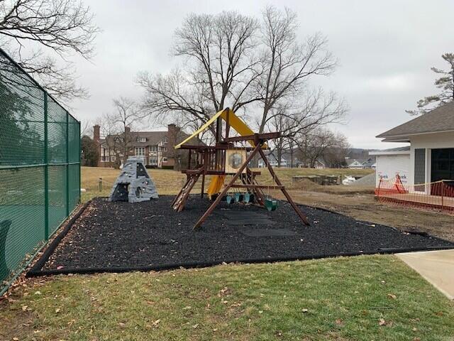 view of jungle gym featuring fence and a lawn