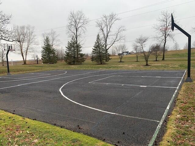 view of basketball court with community basketball court and a lawn