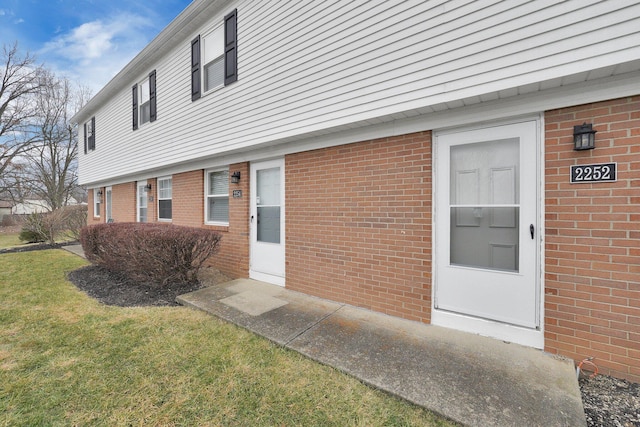 view of exterior entry featuring a yard