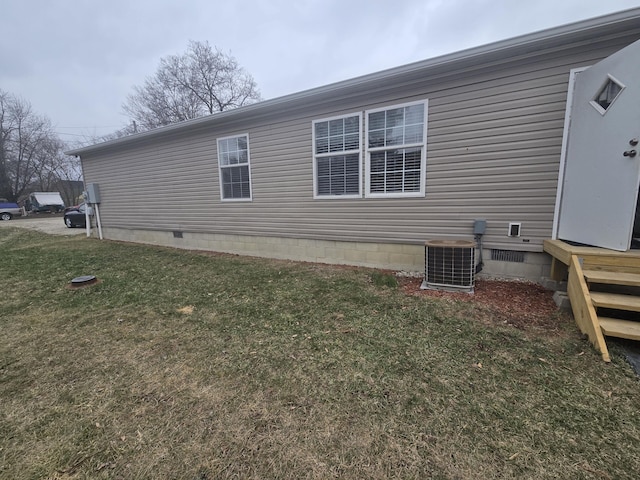 view of home's exterior featuring central AC unit and a lawn