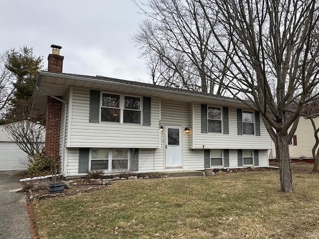 split foyer home featuring a garage and a front lawn