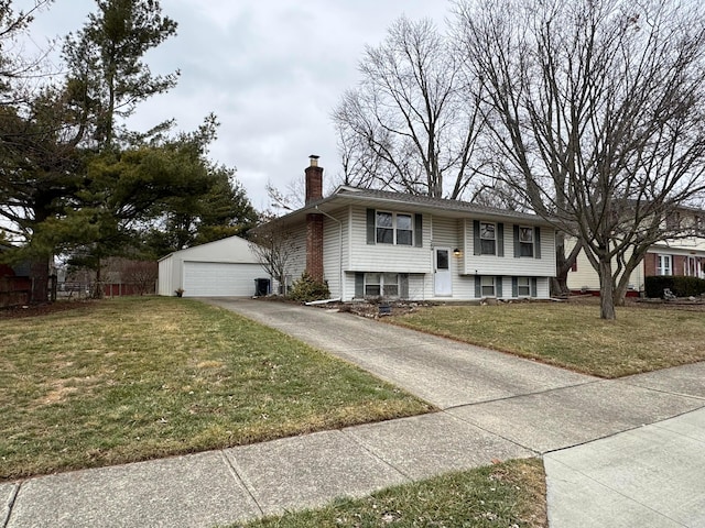 view of front of home with a garage, an outdoor structure, and a front yard