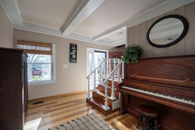 miscellaneous room featuring beamed ceiling, plenty of natural light, and light hardwood / wood-style flooring