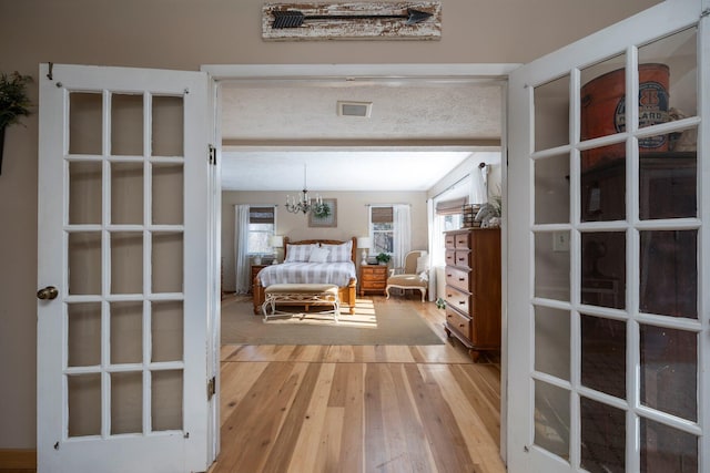 bedroom with a chandelier and light hardwood / wood-style floors