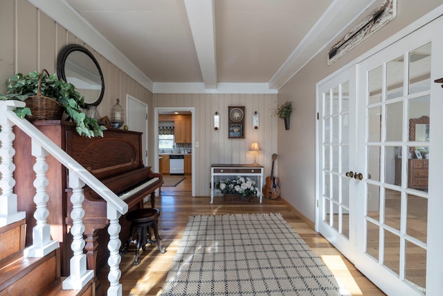 interior space with beamed ceiling, ornamental molding, hardwood / wood-style floors, and french doors