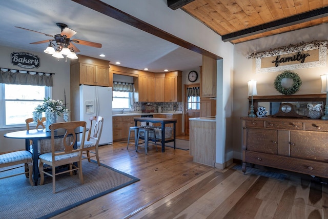 dining space with sink, wood ceiling, hardwood / wood-style flooring, ceiling fan, and beam ceiling