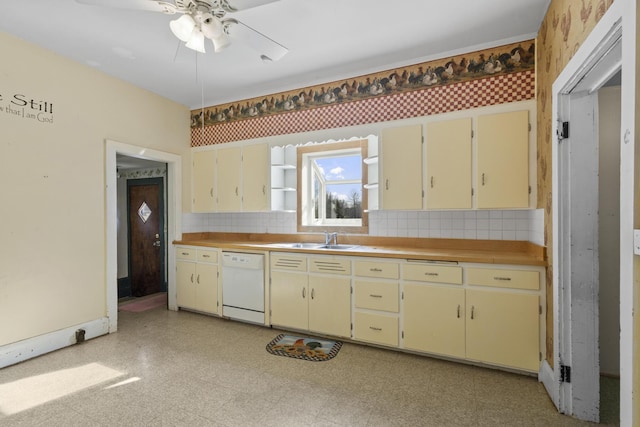 kitchen featuring dishwasher, sink, backsplash, ceiling fan, and cream cabinetry