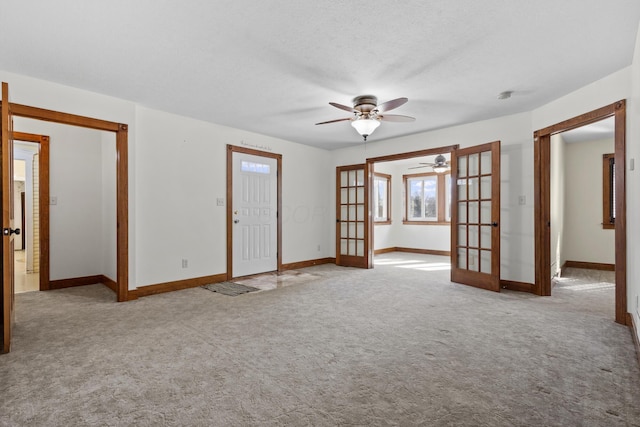 spare room with light carpet, ceiling fan, french doors, and a textured ceiling