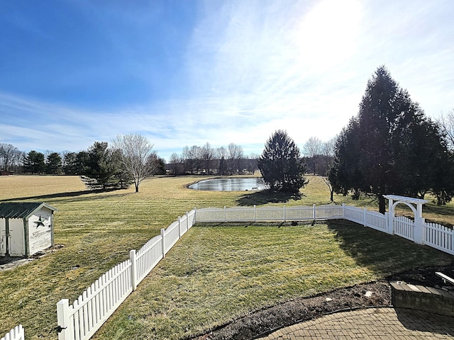 view of yard featuring a water view and a storage unit