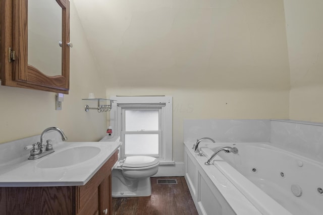 bathroom featuring vanity, toilet, hardwood / wood-style floors, and a tub