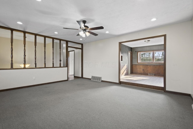 unfurnished living room with a textured ceiling, carpet floors, and ceiling fan