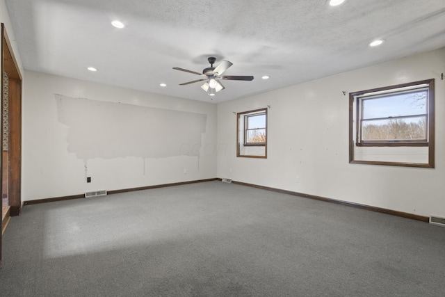 empty room featuring ceiling fan, carpet, and a textured ceiling