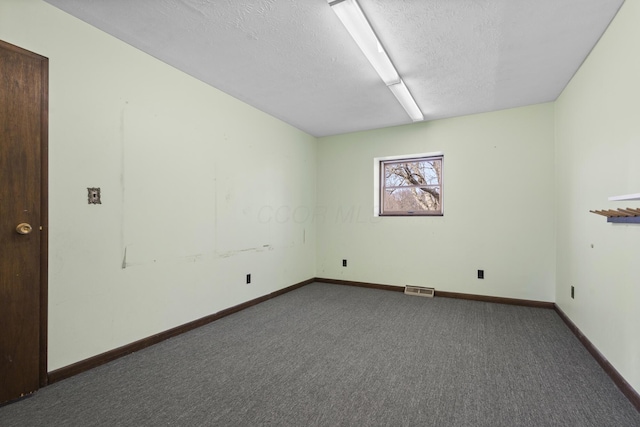 carpeted empty room with a textured ceiling