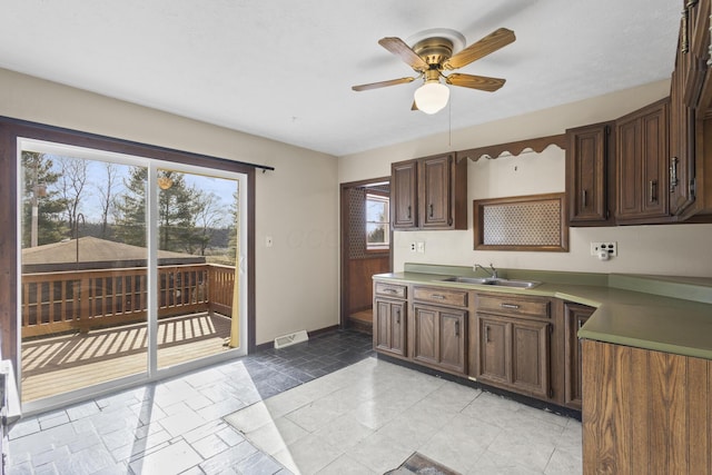 kitchen with dark brown cabinetry, sink, and ceiling fan