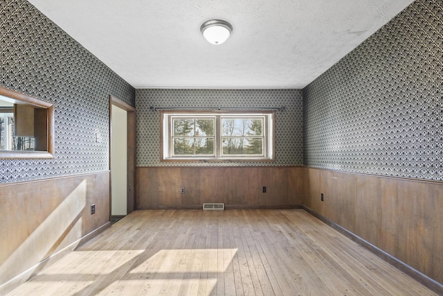 unfurnished bedroom with a textured ceiling and light hardwood / wood-style flooring