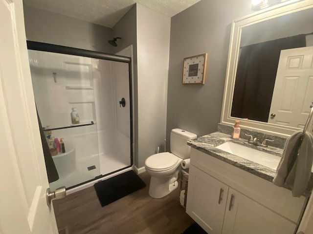 bathroom featuring vanity, hardwood / wood-style flooring, a textured ceiling, and walk in shower