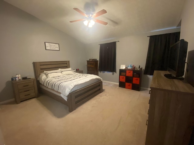 bedroom with vaulted ceiling, light colored carpet, and ceiling fan