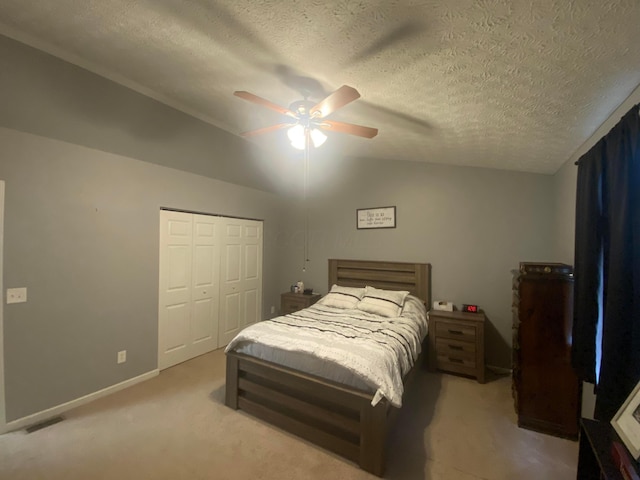 carpeted bedroom with lofted ceiling, a textured ceiling, a closet, and ceiling fan