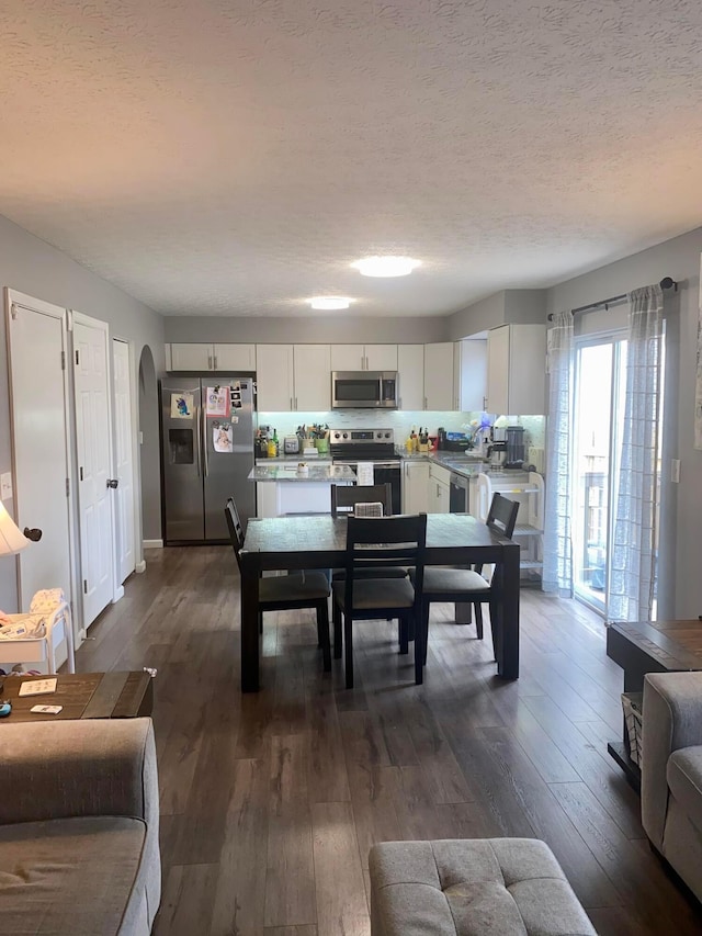 dining room with dark hardwood / wood-style flooring and a textured ceiling