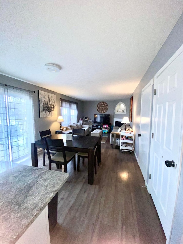 dining area with dark hardwood / wood-style flooring and a textured ceiling