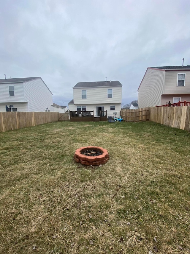 back of house featuring a yard and an outdoor fire pit