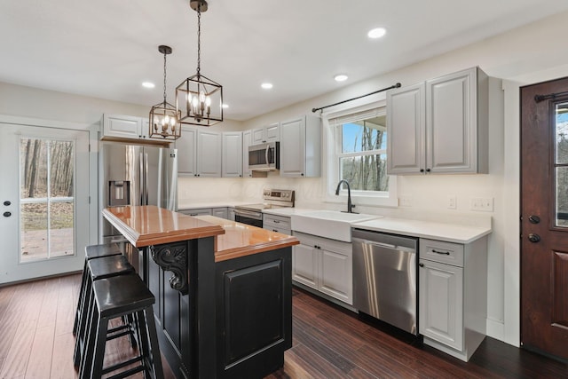 kitchen featuring pendant lighting, sink, a breakfast bar area, stainless steel appliances, and a kitchen island