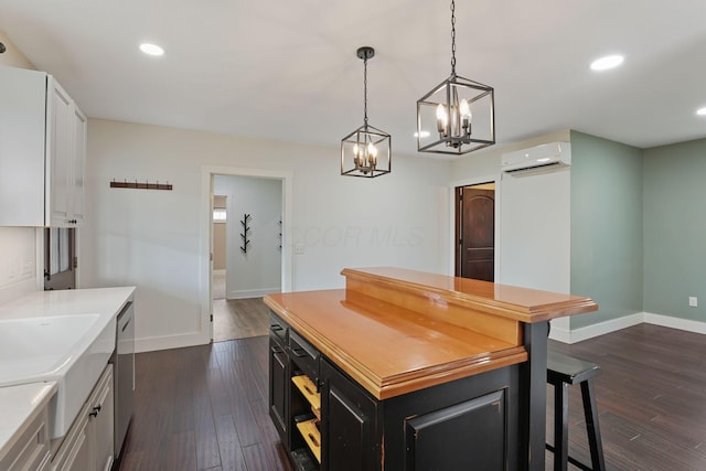 kitchen with dishwasher, white cabinetry, a center island, and a wall mounted AC