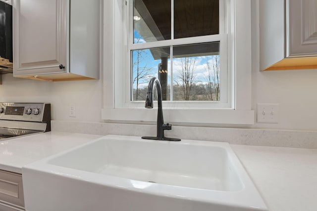 details featuring sink and stainless steel range with electric cooktop