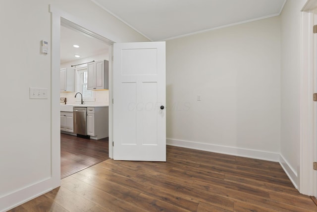 unfurnished room with crown molding, dark hardwood / wood-style floors, and sink