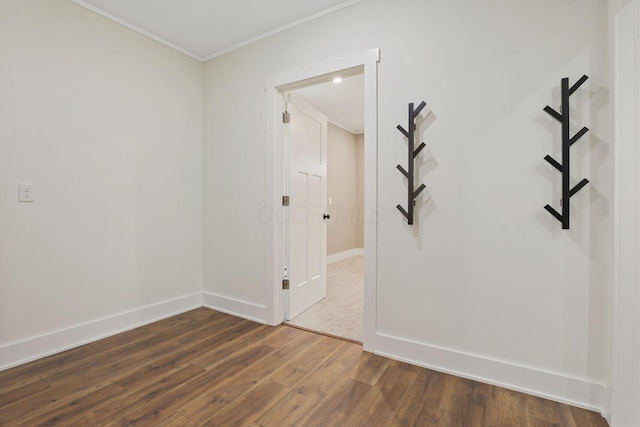 empty room featuring ornamental molding and dark hardwood / wood-style floors