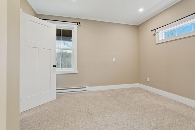 empty room featuring light carpet and a baseboard heating unit