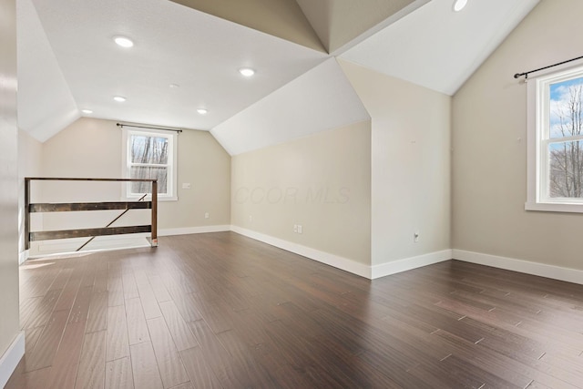 bonus room with lofted ceiling and dark wood-type flooring