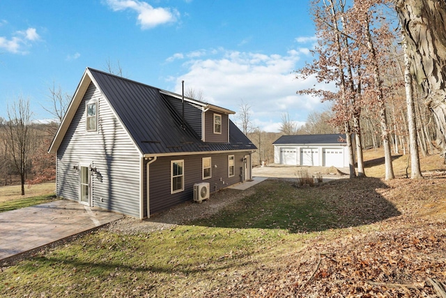 rear view of property with a garage, an outdoor structure, and ac unit