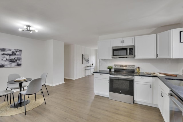 kitchen featuring white cabinetry, appliances with stainless steel finishes, decorative backsplash, and light hardwood / wood-style flooring