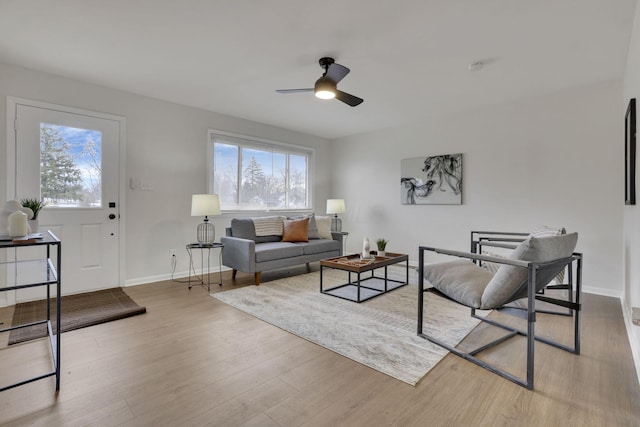 living room with ceiling fan and light hardwood / wood-style flooring