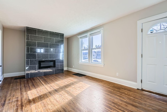 unfurnished living room with a wealth of natural light, hardwood / wood-style flooring, and a fireplace