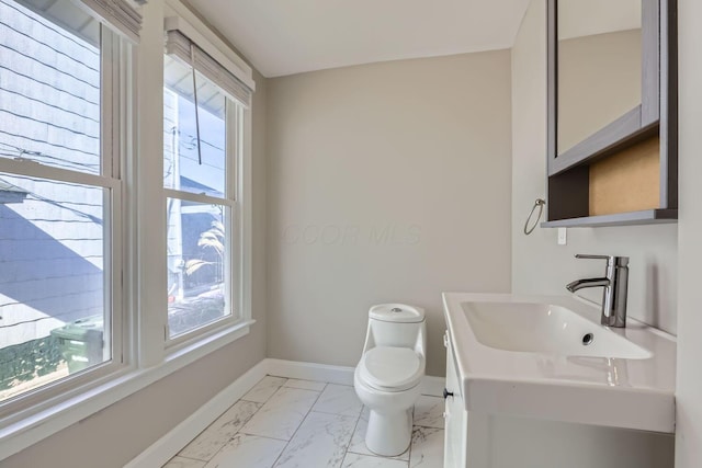 bathroom featuring plenty of natural light, vanity, and toilet