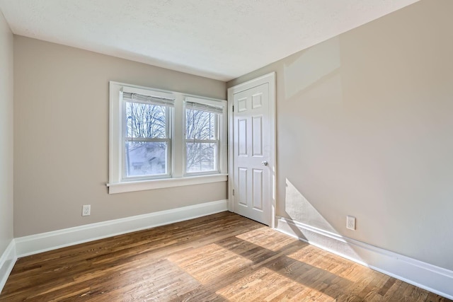 unfurnished room with wood-type flooring