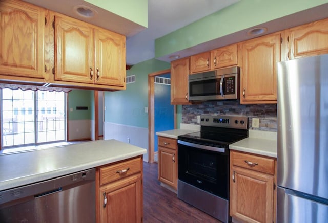 kitchen featuring stainless steel appliances, dark wood-type flooring, and decorative backsplash