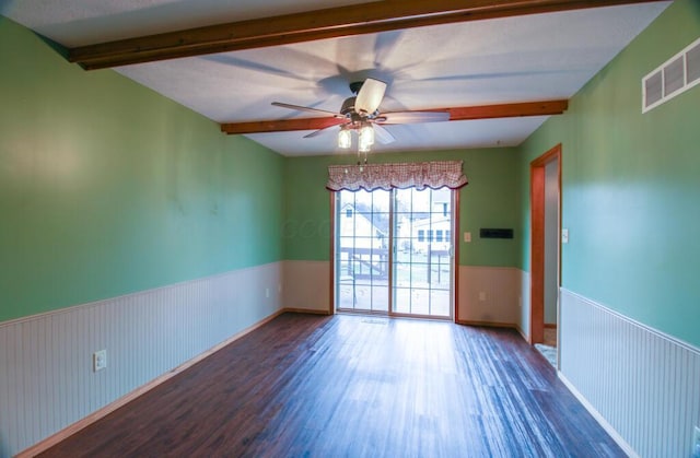 unfurnished room featuring ceiling fan, dark wood-type flooring, and beam ceiling