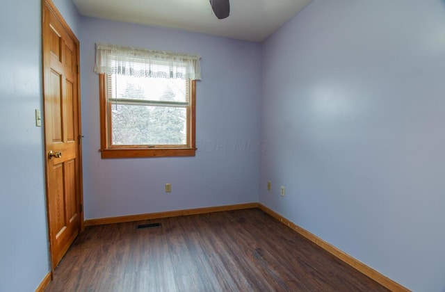 empty room with dark wood-type flooring and ceiling fan