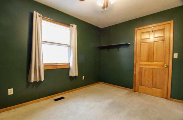 empty room with carpet flooring and ceiling fan