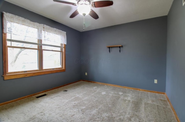 carpeted spare room with ceiling fan