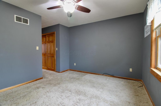 carpeted spare room featuring ceiling fan